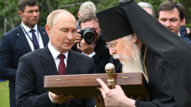 Президент РФ Владимир Путин и архиепископ Ситкинский и Аляскинский Алексий после возложения цветов к могилам советских воинов на мемориальном кладбище Форт Ричардсон на Аляске