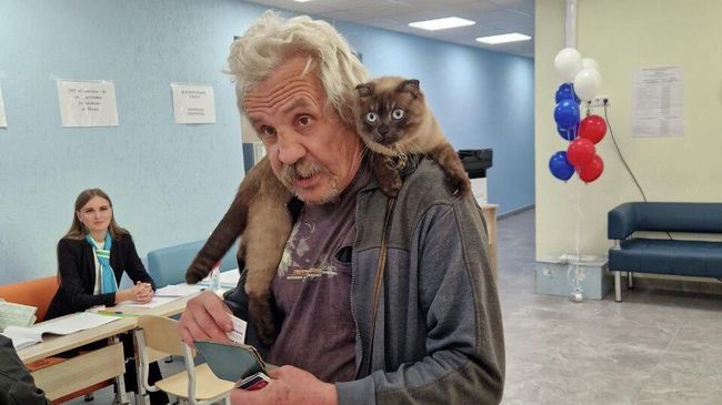 Мужчина с котом голосует на избирательном участке на выборах губернатора Свердловской области