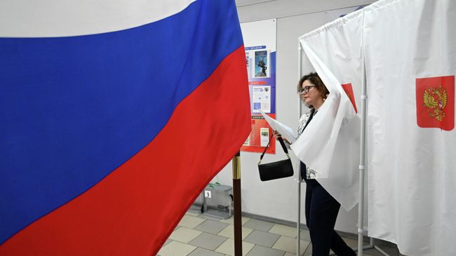 Женщина голосует на выборах