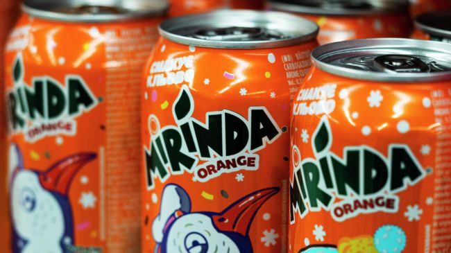 Банки Mirinda на полке в супермаркете
