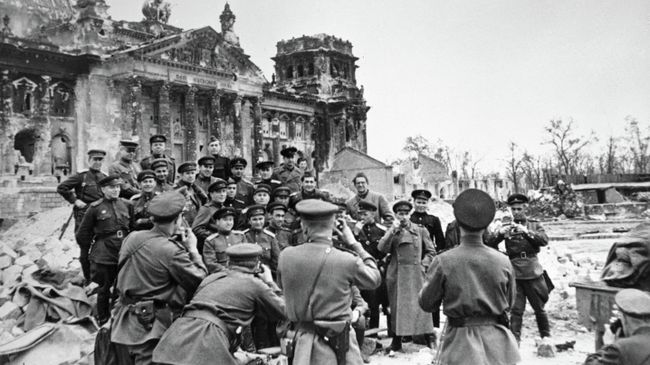 Военные корреспонденты фотографируются у стен поверженного Рейхстага, Берлин, 5 мая 1945 года