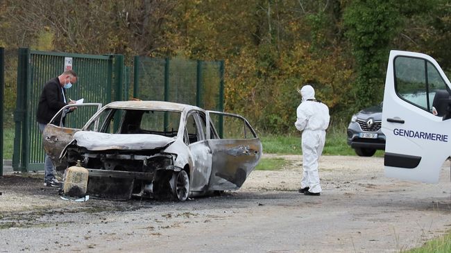 Следователи осматривают сгоревший автомобиль после того, как водитель совершившил намеренный наезд на людей на острове Олерон 