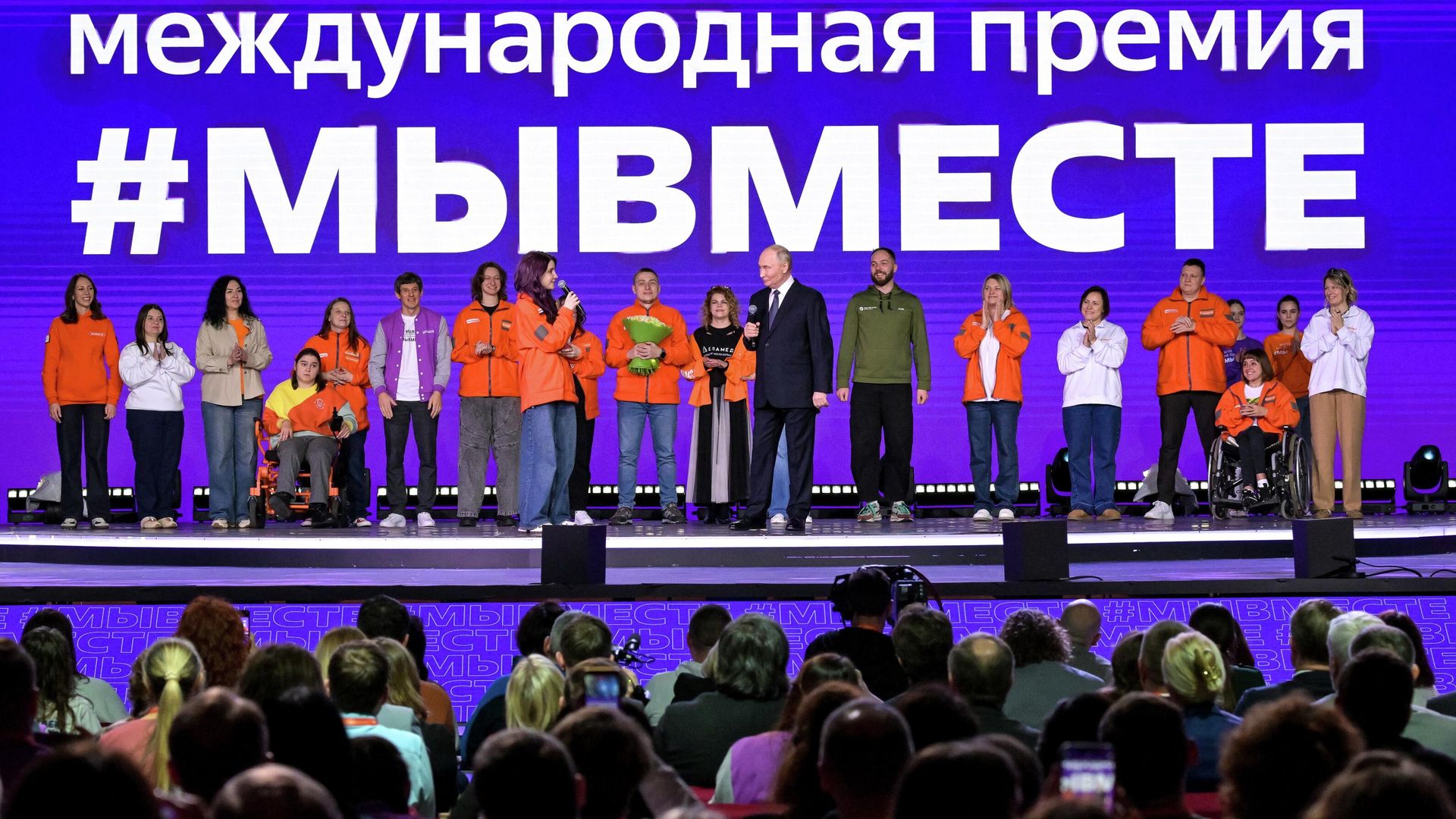 Президент РФ Владимир Путин и Анна Плужникова (восьмая слева), получившая награду в номинации Волонтер года, на церемонии награждения победителей международной премии #МЫВМЕСТЕ Президент РФ Владимир Путин и Анна Плужникова (восьмая слева), получившая награду в номинации Волонтер года, на церемонии награждения победителей международной премии #МЫВМЕСТЕ - РИА Новости, 1920, 03.12.2025