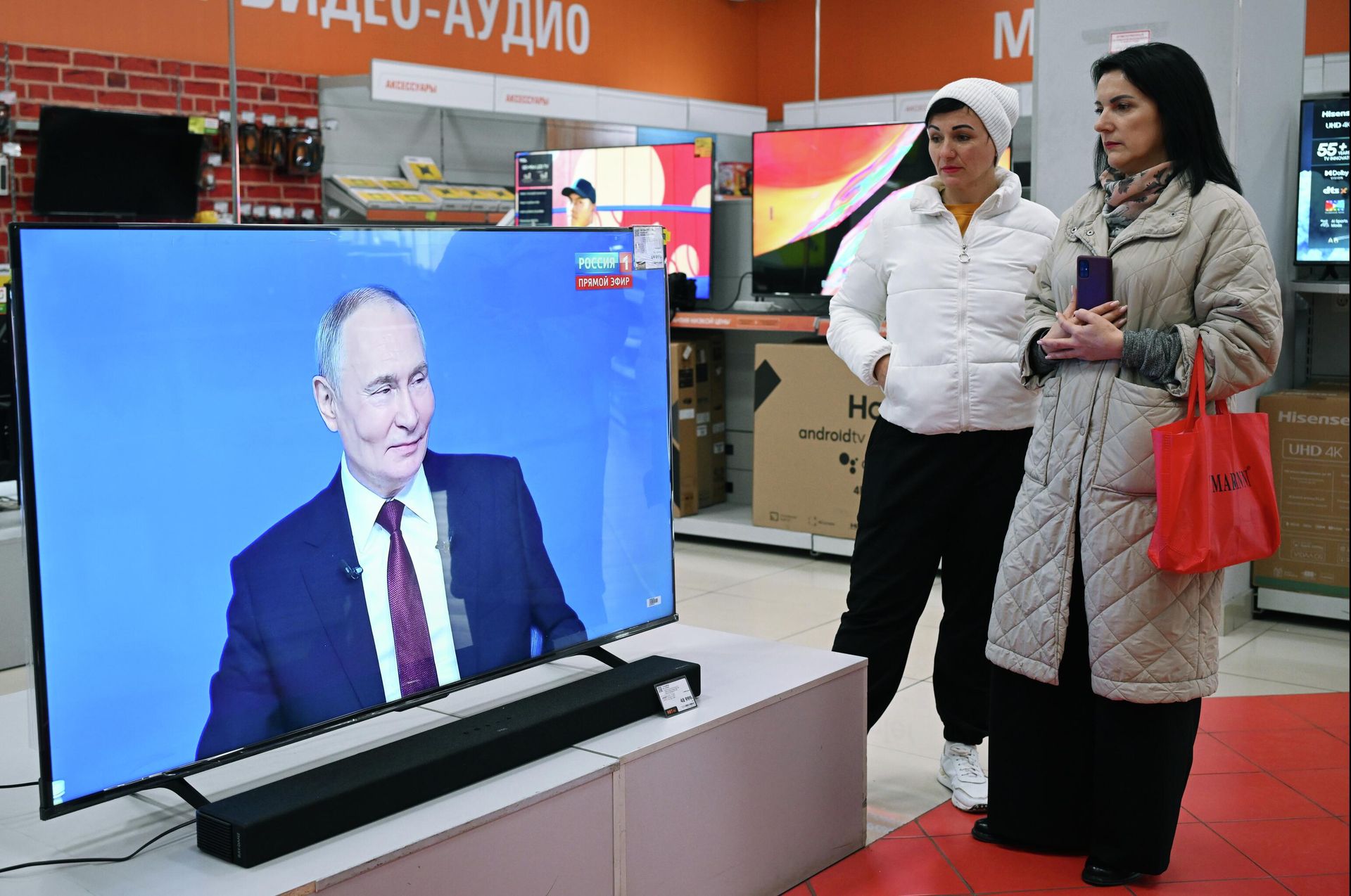 Женщины смотрят трансляцию специальной программы Итоги года с Владимиром Путиным в Симферополе - РИА Новости, 1920, 19.12.2025