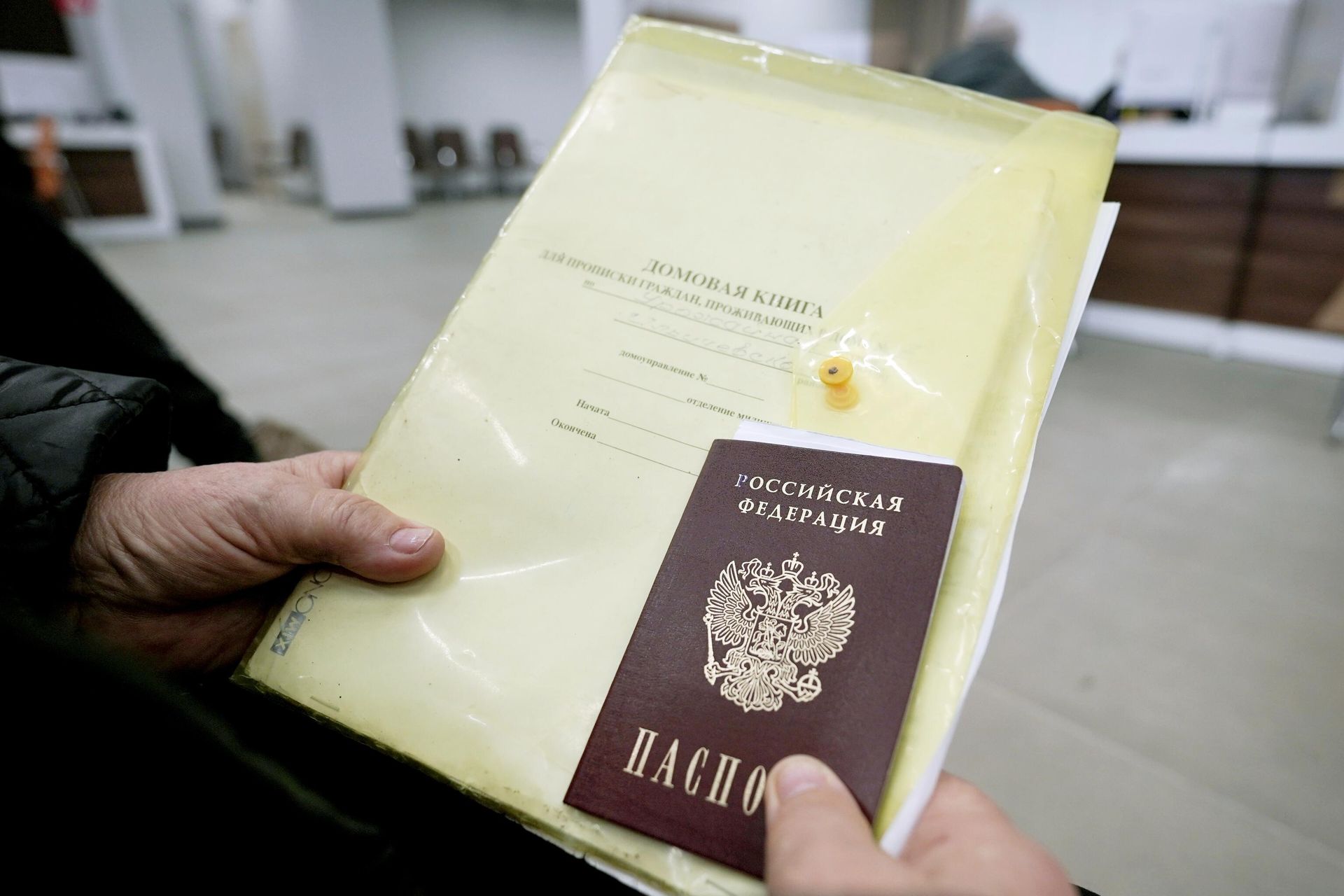 Документы в руках одного из жителей Мариуполя на приеме в отделении многофункционального центра предоставления государственных и муниципальных услуг (МФЦ) Мои документы  - РИА Новости, 1920, 07.09.2026