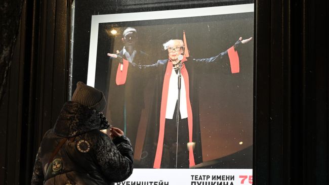Женщина у афиши спектакля Мадам Рубинштейн в Театре имени Пушкина