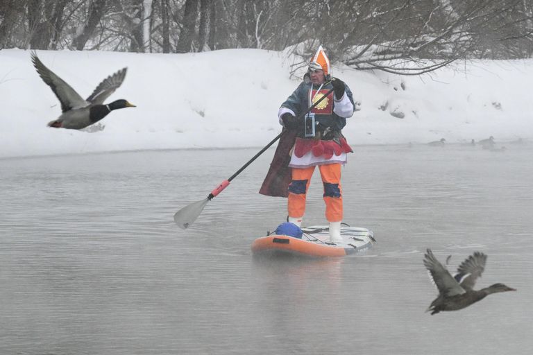 Участник клуба сапсерфинга SUP-Novosibirsk во время новогоднего костюмированного заплыва по незамерзающей реке под Новосибирском