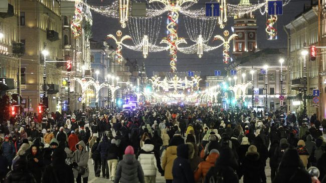 Люди гуляют по Невскому проспекту в Санкт-Петербурге на праздновании Нового года