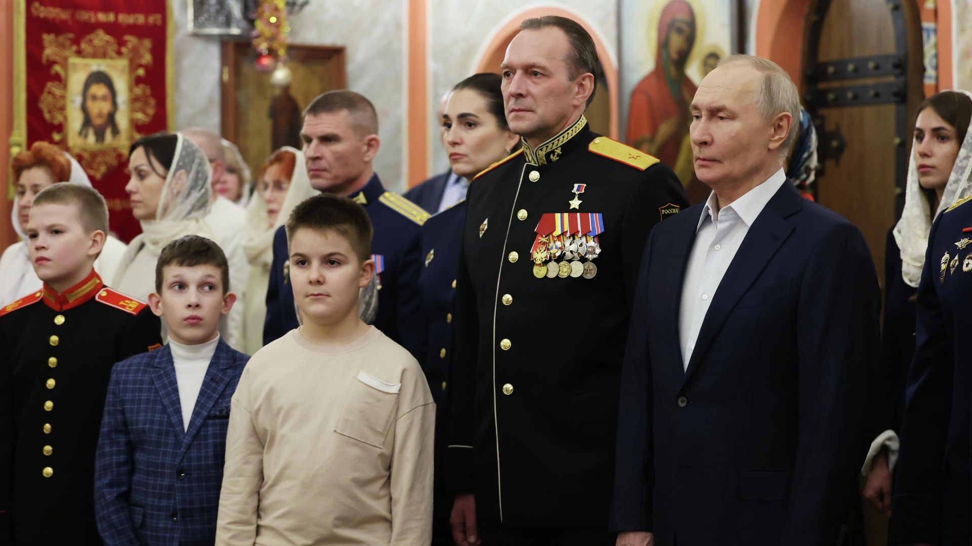 Президент РФ Владимир Путин и военнослужащие с семьями на богослужении в честь Рождества Христова в храме в Московской области - РИА Новости, 1920, 07.01.2026