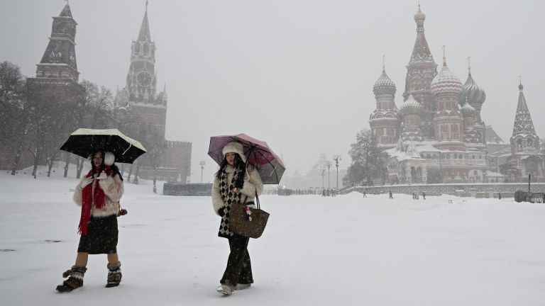 Иностранные туристы во время снегопада на Красной площади в Москве Иностранные туристы во время снегопада на Красной площади в Москве