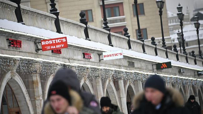 Прохожие около сети быстрого питания Rostic's на Манежной площади в Москве Прохожие около сети быстрого питания Rostic's на Манежной площади в Москве