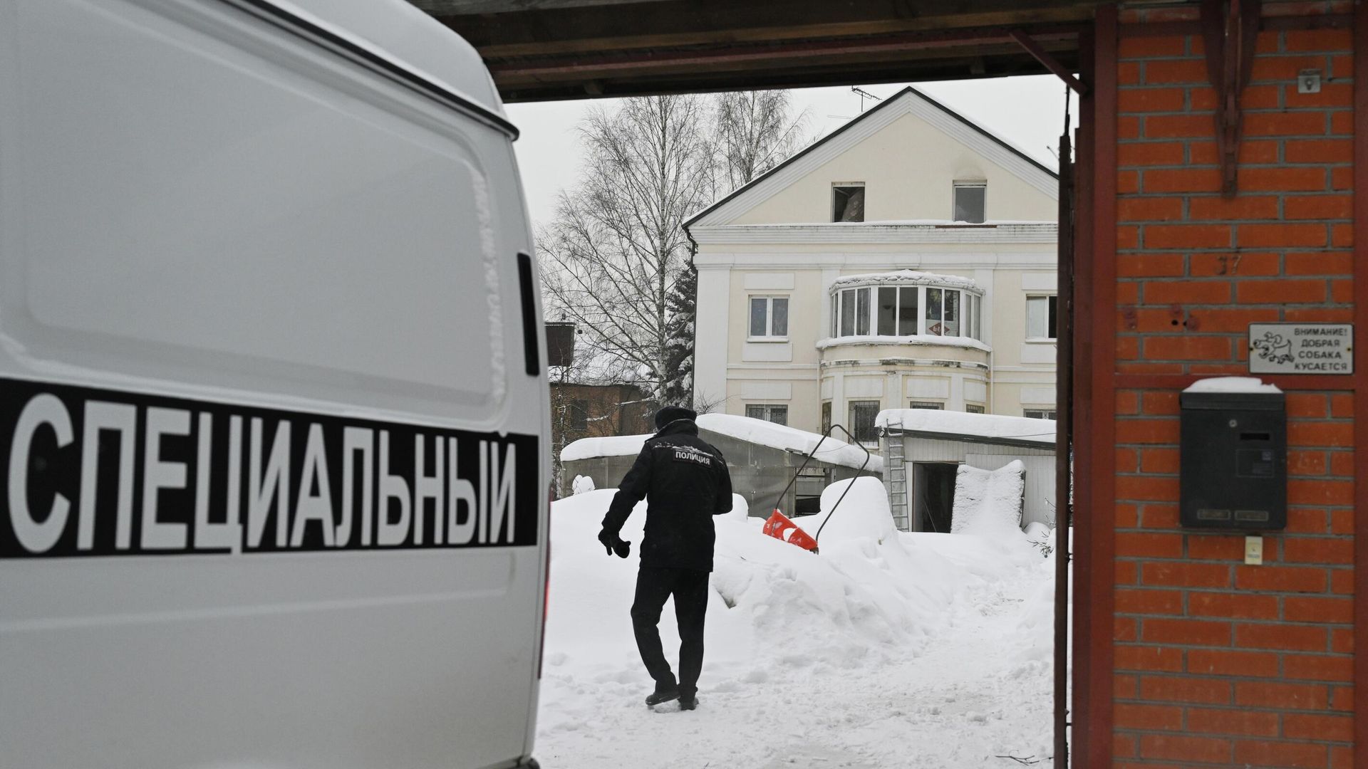 Автомобиль ритуальной службы и сотрудник полиции около частного дома в Балашихе Московской области, где произошел пожар. 27 января 2026 - РИА Новости, 1920, 27.01.2026