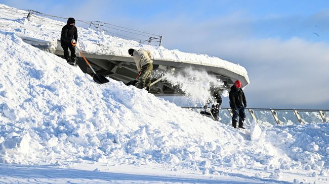 Уборка снега с крыши концертного зала в парке Зарядье в Москве
