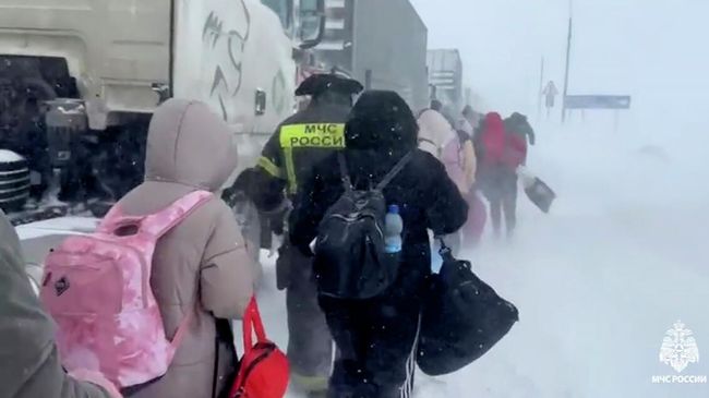 Сотрудники МЧС России провожают детей из застрявшего в пробке на трассе Дон автобуса в резервный транспорт