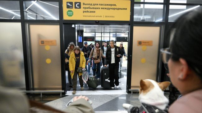 Пассажиры на выходе из зоны прилета международных рейсов в аэропорту Шереметьево в Подмосковье