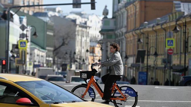 Девушка катается на велосипеде по Пятницкой улице в Москве