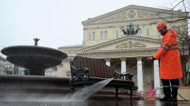 Сотрудник коммунальной службы проводит весеннюю промывку скамьи у Большого театра в Москве. 6 апреля 2026