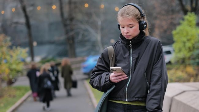 Девушка слушает музыку на одной из улиц в Москве