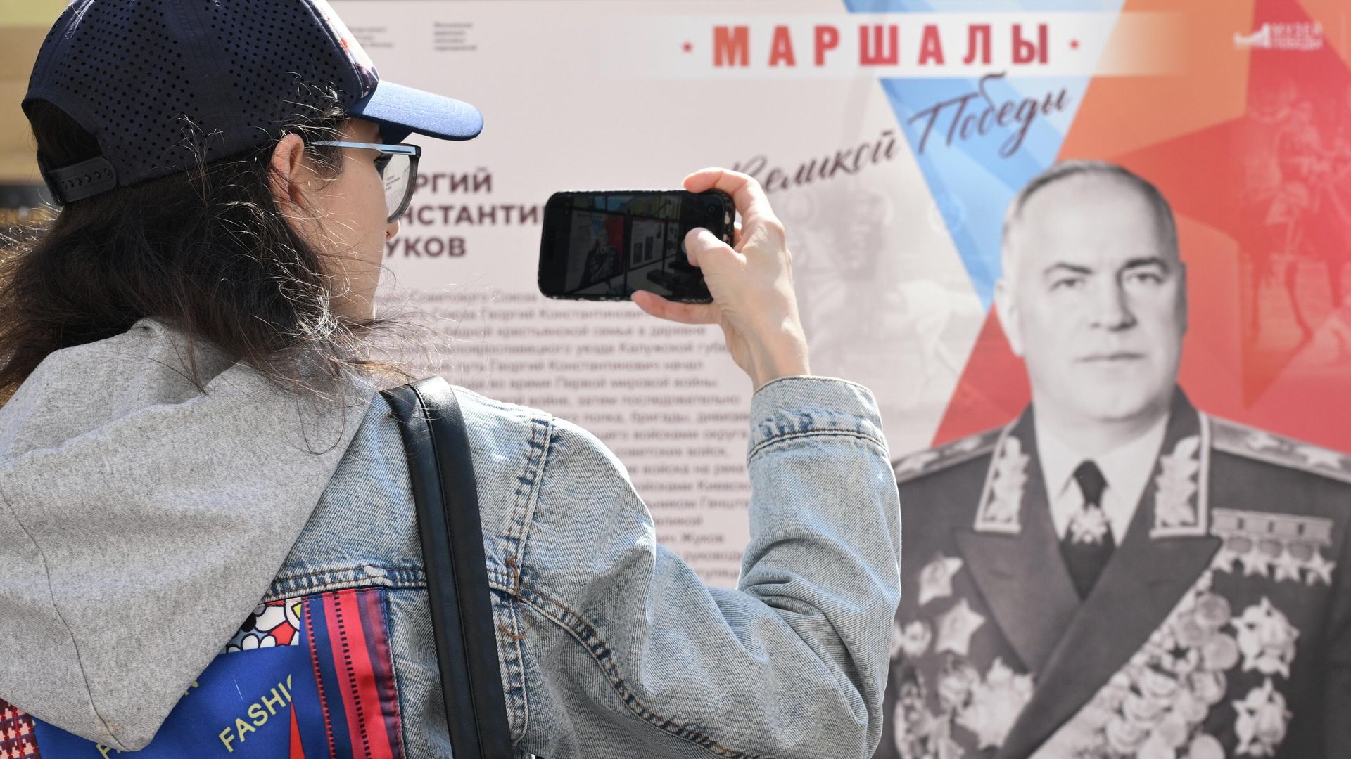 Посетитель на фотовыставке Маршалы Великой Победы на улице Арбат в Москве Посетитель на фотовыставке Маршалы Великой Победы на улице Арбат в Москве - РИА Новости, 1920, 06.05.2026