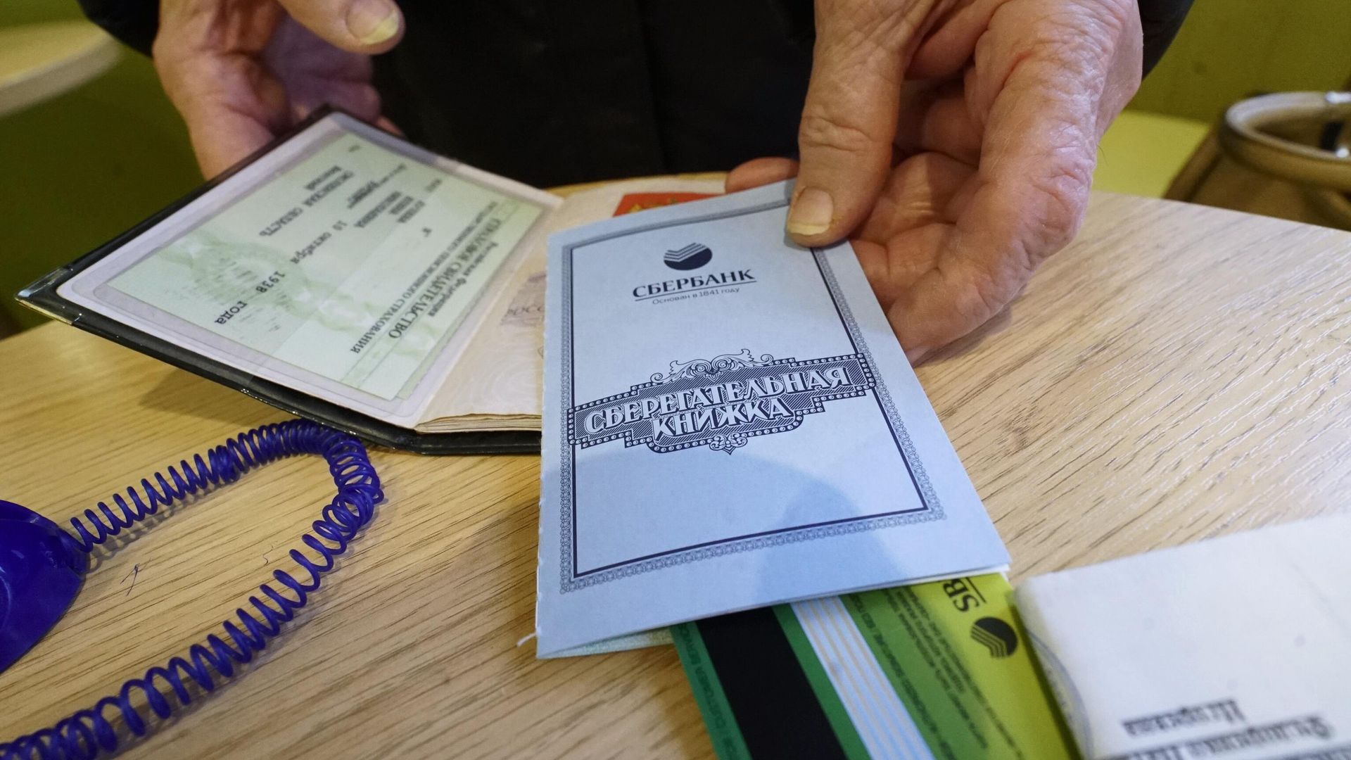 Сберегательная книжка и паспорт посетителя Сбербанка Сберегательная книжка и паспорт посетителя Сбербанка - РИА Новости, 1920, 21.05.2026