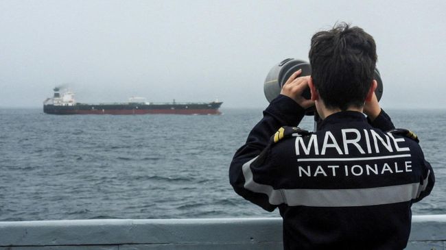 Военнослужащий ВМС Франции наблюдает за нефтяным танкером в Атлантическом океане