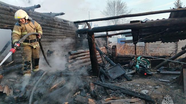 Сотрудник МЧС ликвидирует пожар в садовом товариществе Маяк в Красноярске