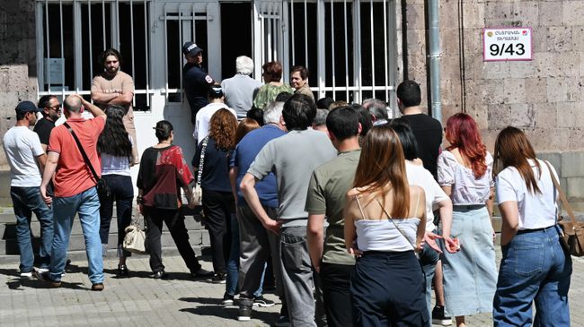 Избиратели пришли на парламентские выборы и стоят в очереди на избирательный участок в Ереване