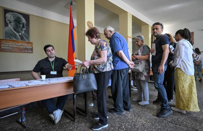 Избиратели получают бюллетени на избирательном участке в Ереване на парламентских выборах