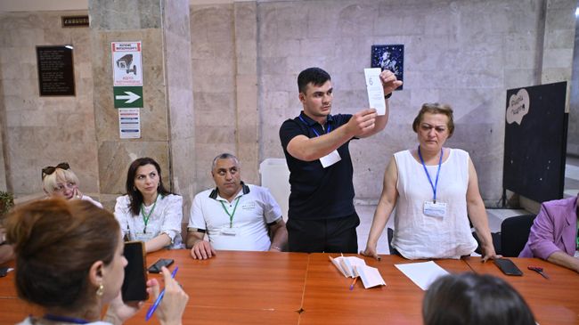 Сотрудники участковой избирательной комиссии во время подсчета избирательных бюллетеней после окончания голосования на парламентских выборах в Ереване