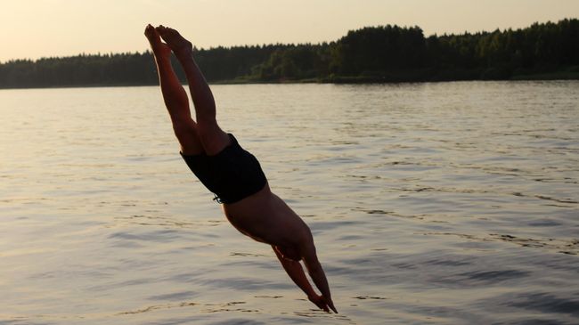 Мужчина ныряет в воду