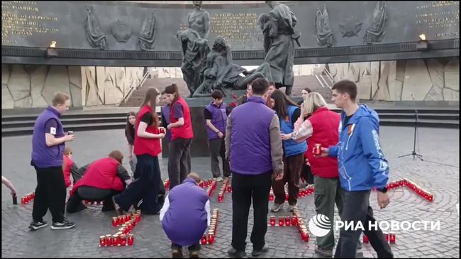 Памятная надпись из свечей у монумента защитникам Ленинграда в Петербурге