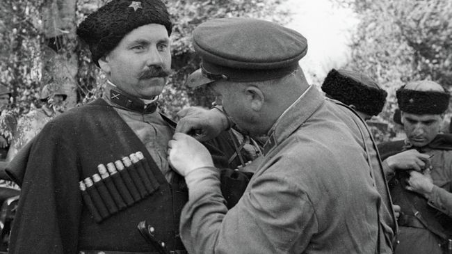 Бригадный комиссар Александр Очкин (справа) награждает отличившихся в боях за Кавказ казаков 