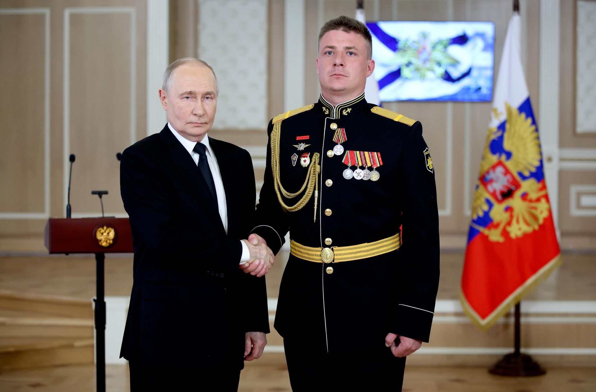 Президент РФ, верховный главнокомандующий ВС РФ Владимир Путин и старший наводчик расчета реактивного артиллерийского взвода 177-го отдельного гвардейского полка морской пехоты Каспийской флотилии Виталий Сучков Президент РФ, верховный главнокомандующий ВС РФ Владимир Путин и старший наводчик расчета реактивного артиллерийского взвода 177-го отдельного гвардейского полка морской пехоты Каспийской флотилии Виталий Сучков - РИА Новости, 1920, 26.07.2026