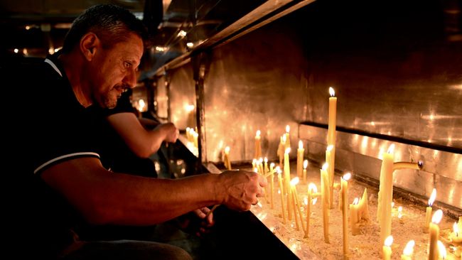 Люди зажгли свечи в память о Ратко Младиче перед церковью в городе Баня-Лука