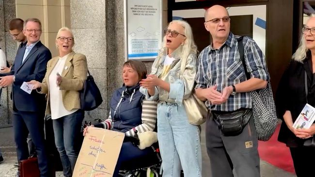 Участники акции против закрытия Русского дома в Берлине поют Пусть всегда будет солнце