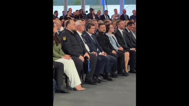 Президент Румынии поправляет носки, сидя с Зеленским