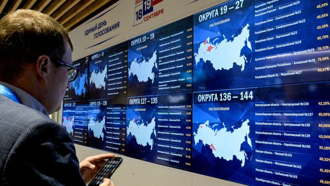 Экран в Информационном центре Центральной избирательной комиссии РФ в Москве, с процентами явки избирателей по округам на выборах депутатов Государственной Думы РФ 9 созыва