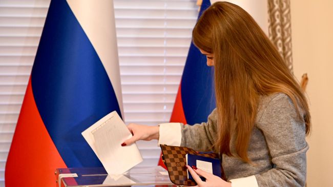 Женщина принимает участие в голосовании на выборах депутатов Государственной Думы РФ девятого созыва на избирательном участке генерального консульства России в Нью-Йорке