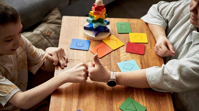 Ребенок играет с преподавателем 