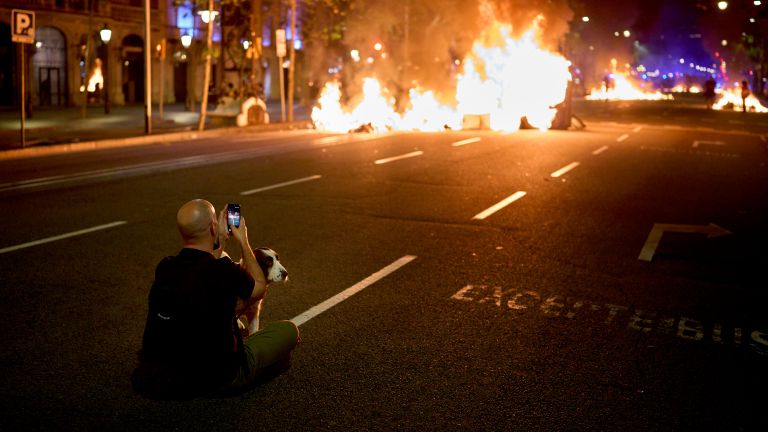 Мужчина фотографирует горящие баррикады во время столкновений с полицией Мужчина фотографирует горящие баррикады во время столкновений с полицией