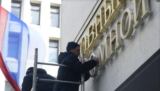 Рабочие устанавливают надпись Верховный Совет вместо демонтированной вывески с названием Верховная Рада на здание парламента Крыма Рабочие устанавливают надпись Верховный Совет вместо демонтированной вывески с названием Верховная Рада на здание парламента Крыма