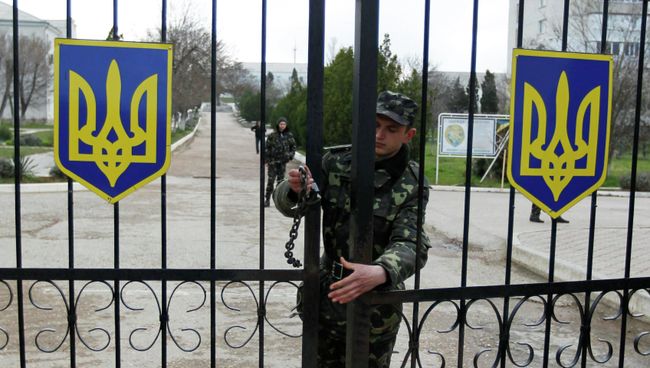 Солдат закрывает ворота на военно-воздушную базу Украины в Бельбеке Солдат закрывает ворота на военно-воздушную базу Украины в Бельбеке