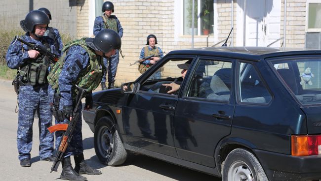 Сотрудники полиции досматривают автомобиль на месте проведения контртеррористической операции у частного дома в Буйнакске. Фото с места события Сотрудники полиции досматривают автомобиль на месте проведения контртеррористической операции у частного дома в Буйнакске. Фото с места события