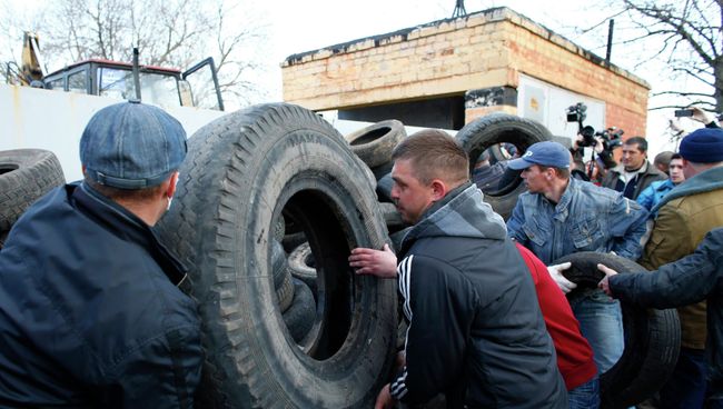 Сторонники федерализации Украины строят баррикаду из покрышек около ворот аэропорта Краматорска Сторонники федерализации Украины строят баррикаду из покрышек около ворот аэропорта Краматорска