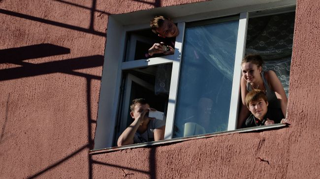 Студенты выглядывают из окна общежития. Архивное фото