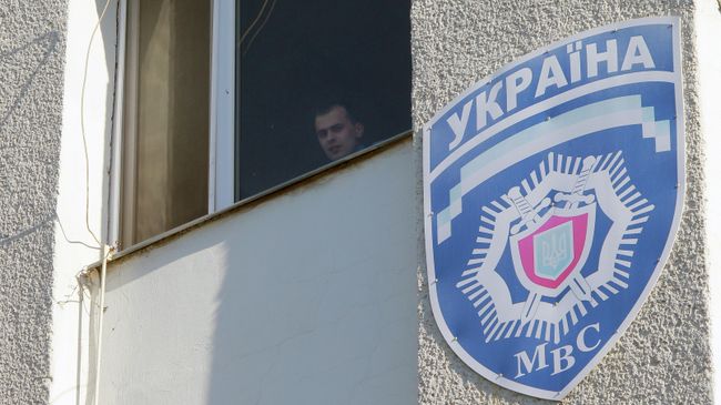Милиционер смотрит из окна здания областного управления МВД Украины Милиционер смотрит из окна здания областного управления МВД Украины