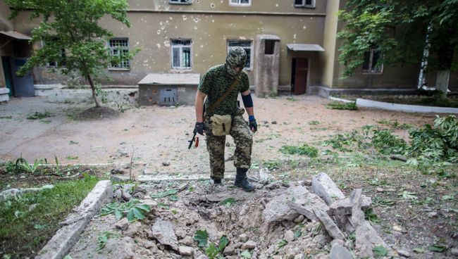 Боец народного ополчения у воронки от снаряда во дворе больницы в поселке Семеновка. Архивное фото Боец народного ополчения у воронки от снаряда во дворе больницы в поселке Семеновка. Архивное фото