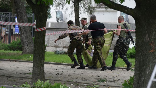 Народные ополченцы несут раненого в результате авианалета ВВС Украины на здание обладминистрации в Луганске Народные ополченцы несут раненого в результате авианалета ВВС Украины на здание обладминистрации в Луганске
