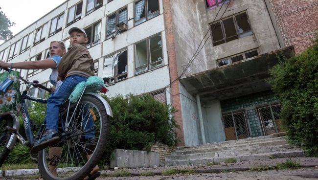 Выбитые стекла в окнах многоэтажного дома после артиллерийского обстрела Славянска