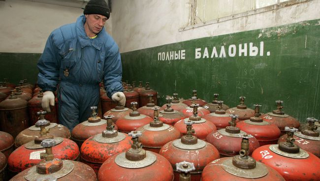 Украинский рабочий у баллонов с газом. Архивное фото Украинский рабочий у баллонов с газом. Архивное фото